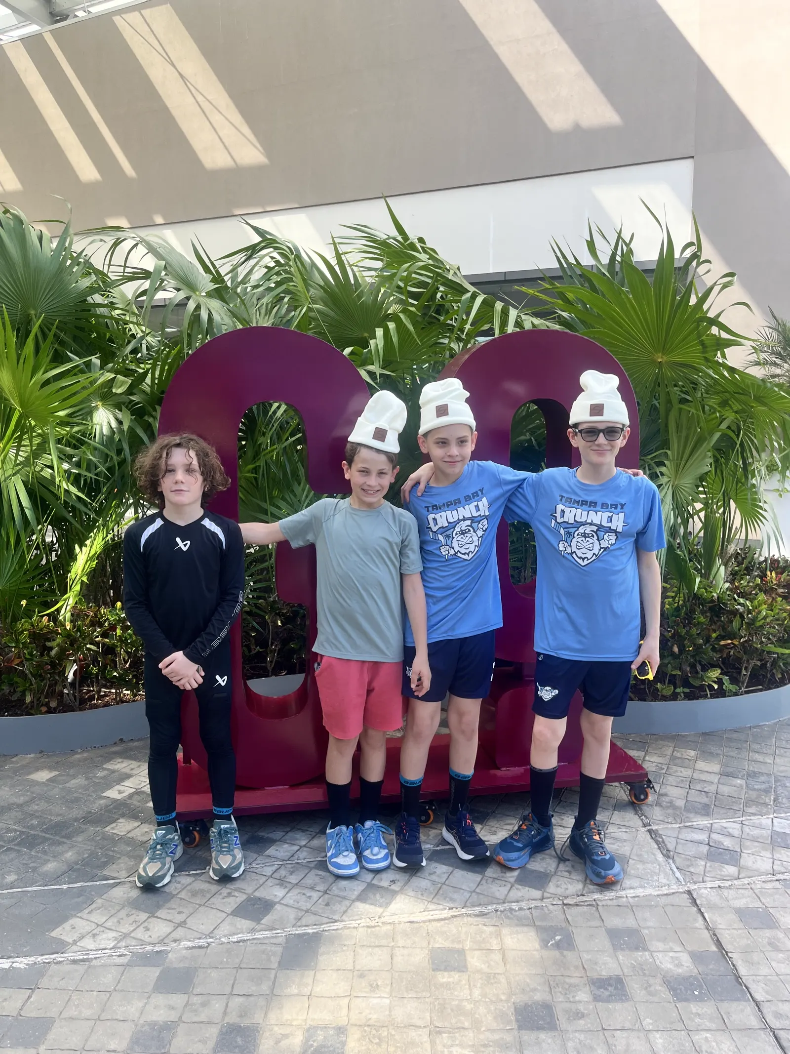 Four young players posing in front of a large resort sign in Cancún